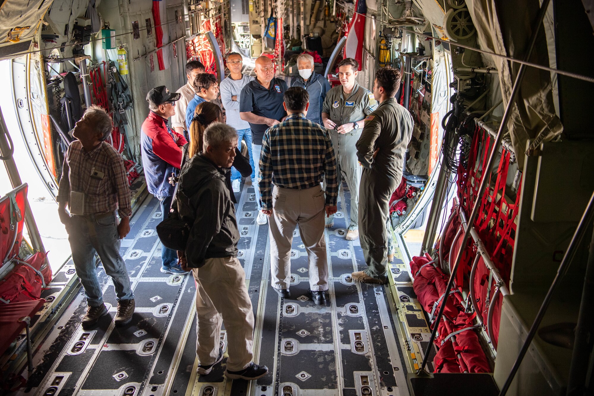 A U.S. Air Force pilot speaks to Japanese civilians inside a military aircraft.