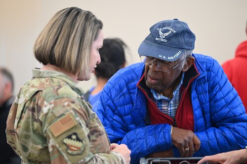 Image of Airman speaking to a retiree during event.