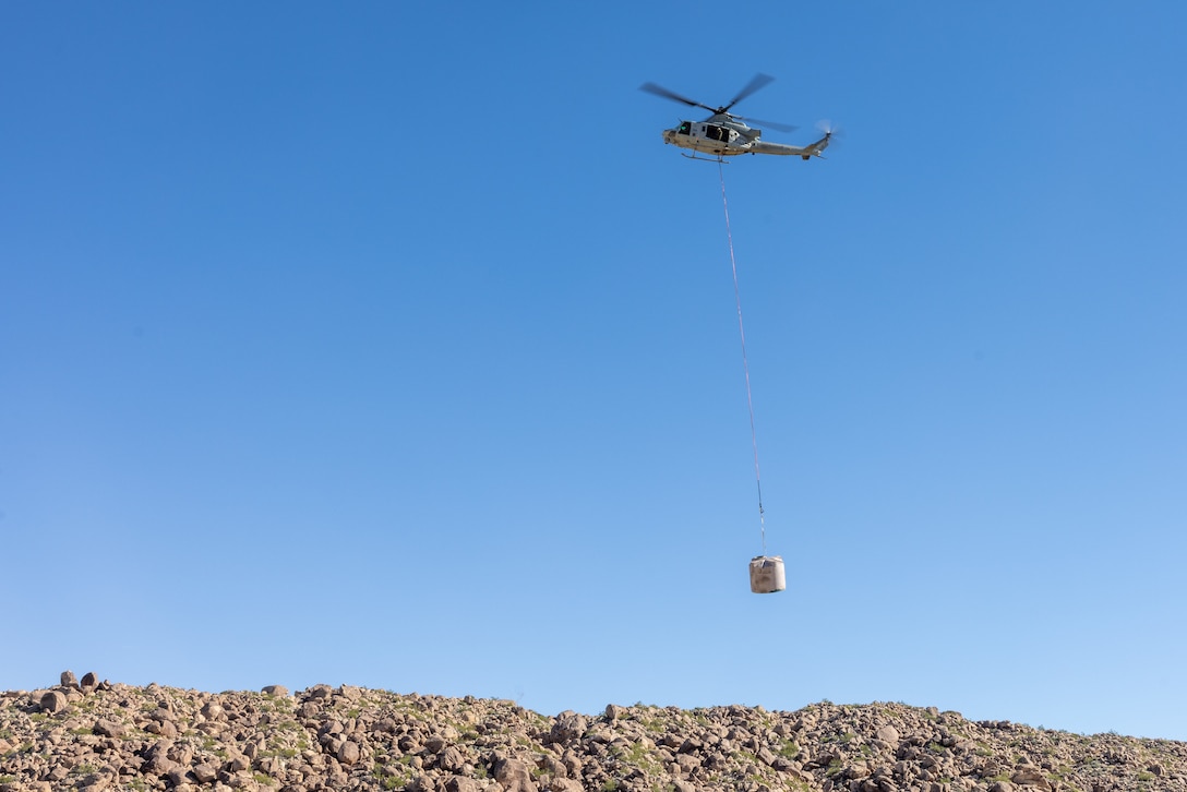 A U.S. Marine Corps UH-1Y Venom with Marine Light Helicopter Attack Training Squadron (HMLAT) 303, Marine Aircraft Group 39, 3rd Marine Aircraft Wing, carries a replacement water guzzler to Harper Canyon located in Anza-Borrego Desert State Park, California, Nov. 5, 2023. HMLAT-303 supported state, federal, and private agencies utilizing long-line external lift capabilities of the UH-1Y to replace water guzzlers throughout the park. Guzzlers are self-filling, constructed watering facilities that collect, store, and make water available for wildlife. (U.S. Marine Corps photo by Chief Warrant Officer 2 Trent Randolph)
