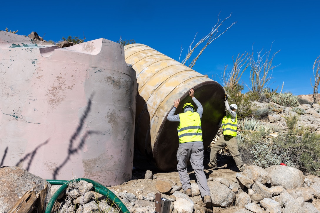 Members of state, federal, and private agencies place a new water guzzler inserted by a U.S. Marine Corps UH-1Y Venom with Marine Light Helicopter Attack Training Squadron (HMLAT) 303, Marine Aircraft Group 39, 3rd Marine Aircraft Wing, at Anza-Borrego Desert State Park, California, Nov. 5, 2023. HMLAT-303 supported state, federal, and private agencies utilizing long-line external lift capabilities of the UH-1Y to replace water guzzlers throughout the park. Guzzlers are self-filling, constructed watering facilities that collect, store, and make water available for wildlife. (U.S. Marine Corps photo by Chief Warrant Officer 2 Trent Randolph)