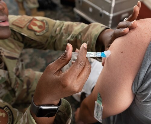 A medical personnel administers the influenza vaccine to a patient.
