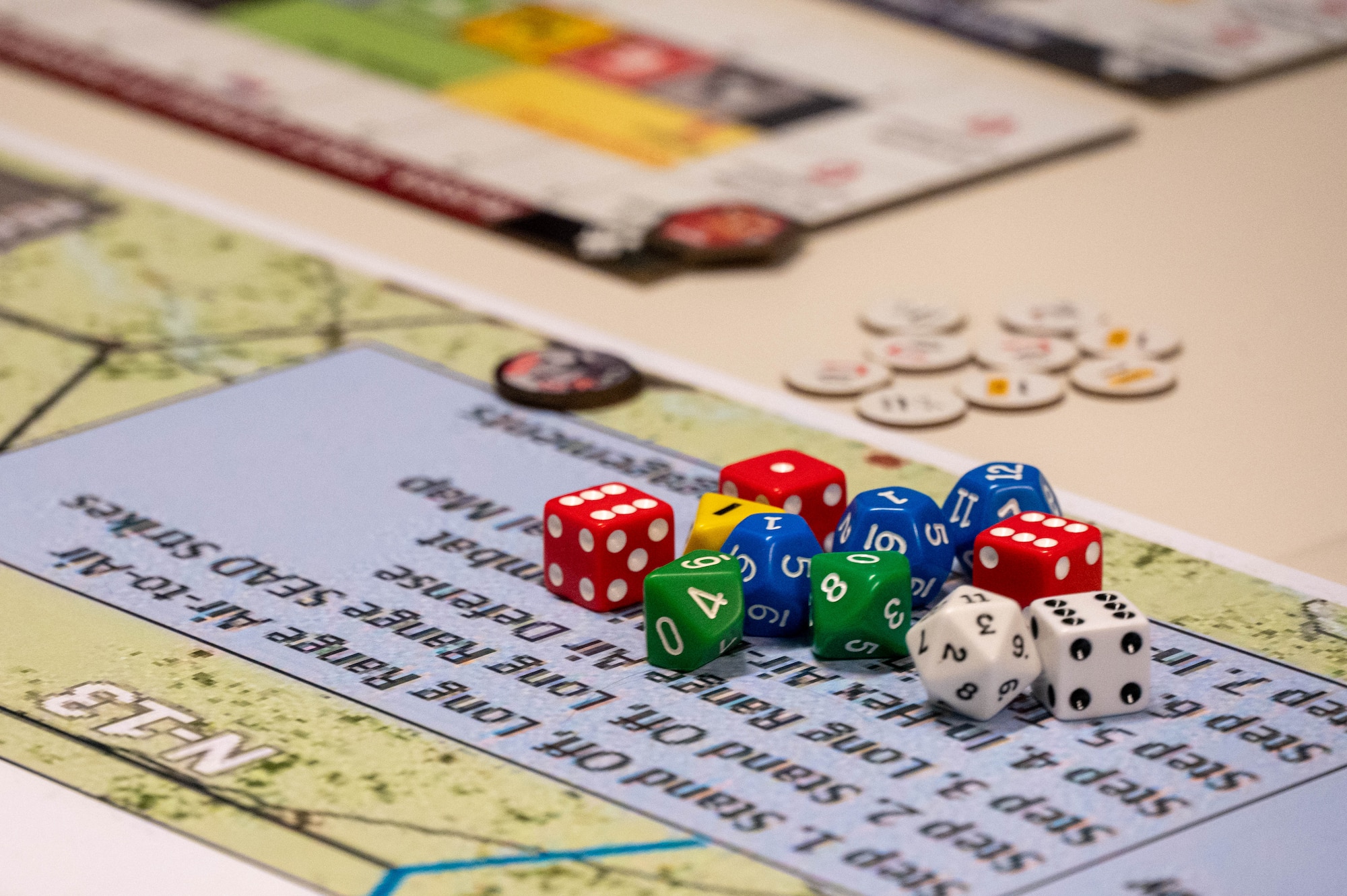 Dice and game tokens sit on a wargaming board.