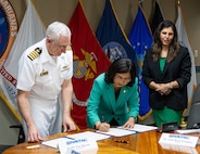 University of Guam President Anita Borja Enriquez, center, signs the Memorandum of Understanding to formalize an internship pathway for UOG’s engineering students on Nov. 1, 2023. Capt. Troy Brown, Commanding Officer of Naval Facilities Engineering Systems Command Marianas, left, signs for NAVFAC as Bharti Hemlani, Lead Human Resources Specialist and acting HR Director at NAVFAC Marianas, facilitates.