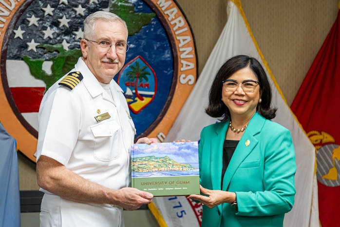 After the signing, Dr. Enriquez, right, presents Capt. Brown with a coffee table book about UOG at NAVFAC Marianas on Nimitz Hill on Nov.1, 2023
