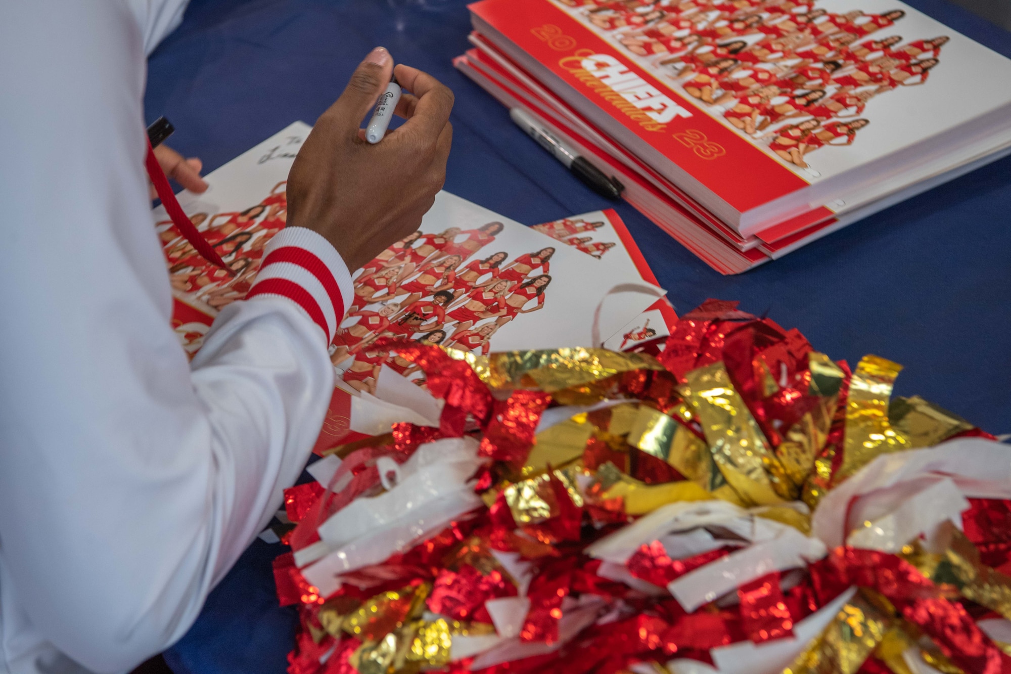 A woman signs a photo