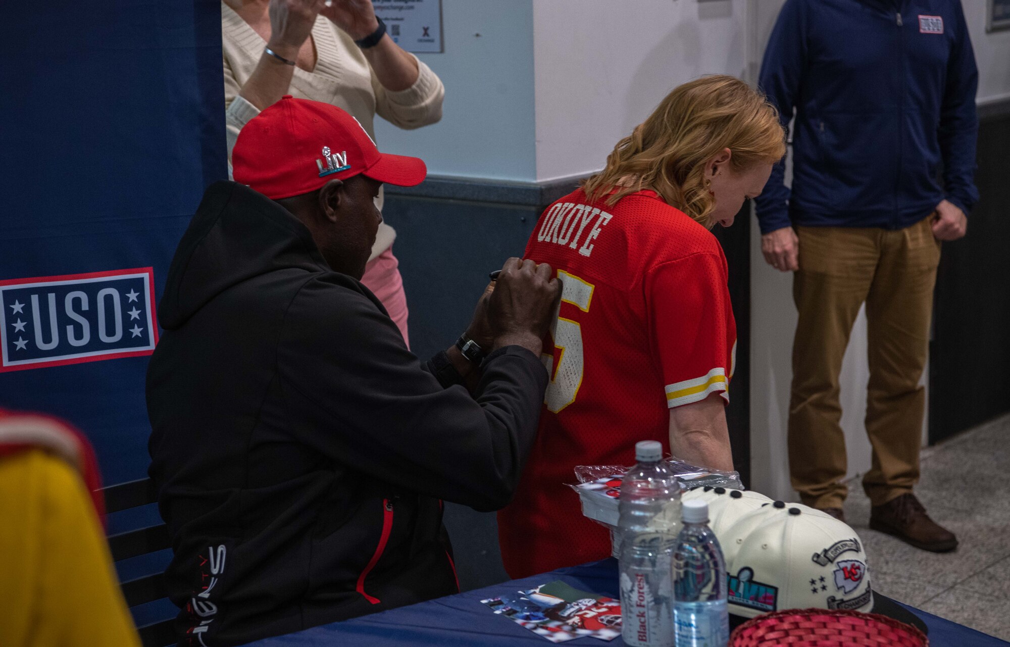 A man signs a woman's jersey