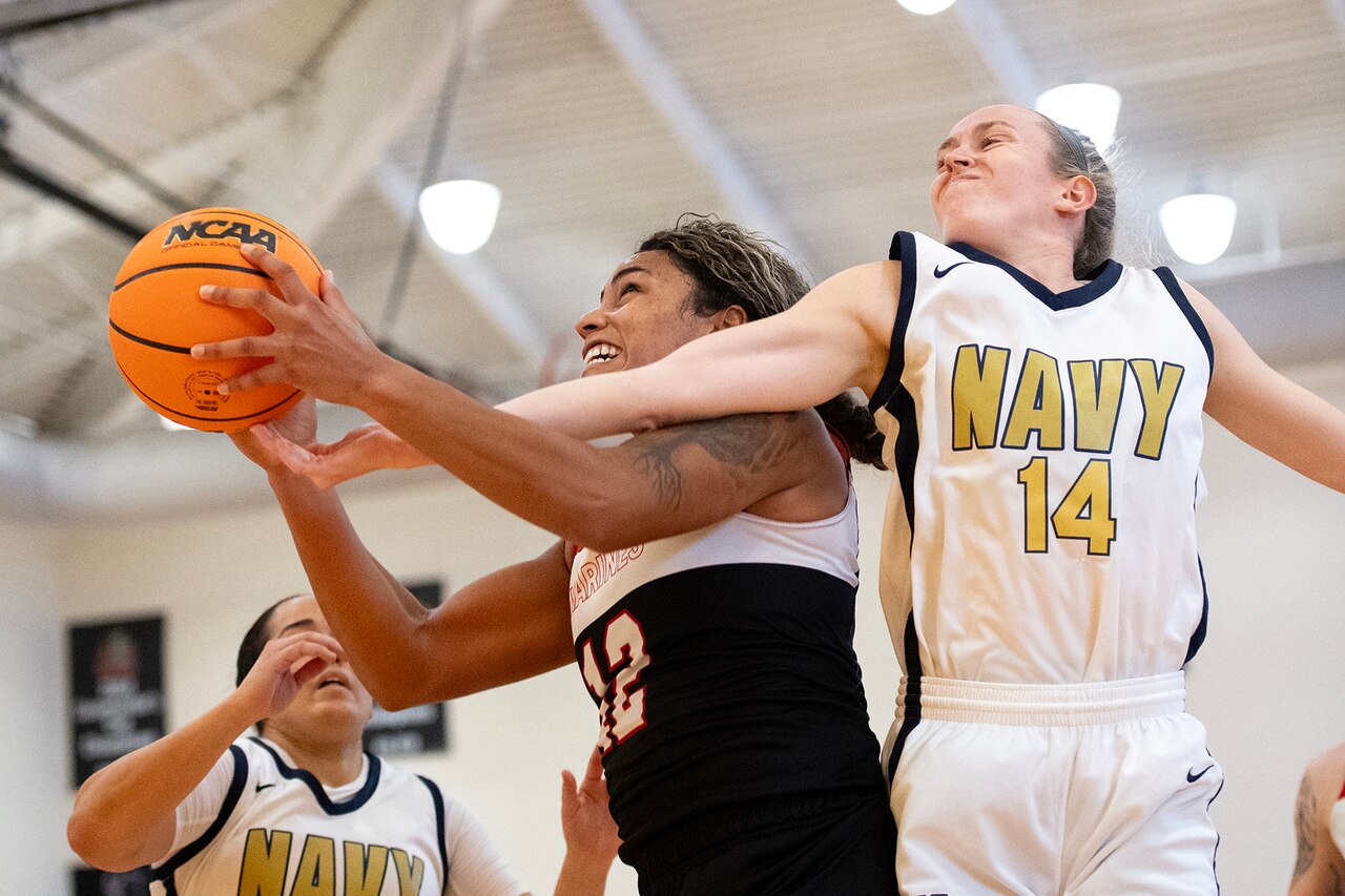 Two basketball players fight for a rebound during a basketball game.