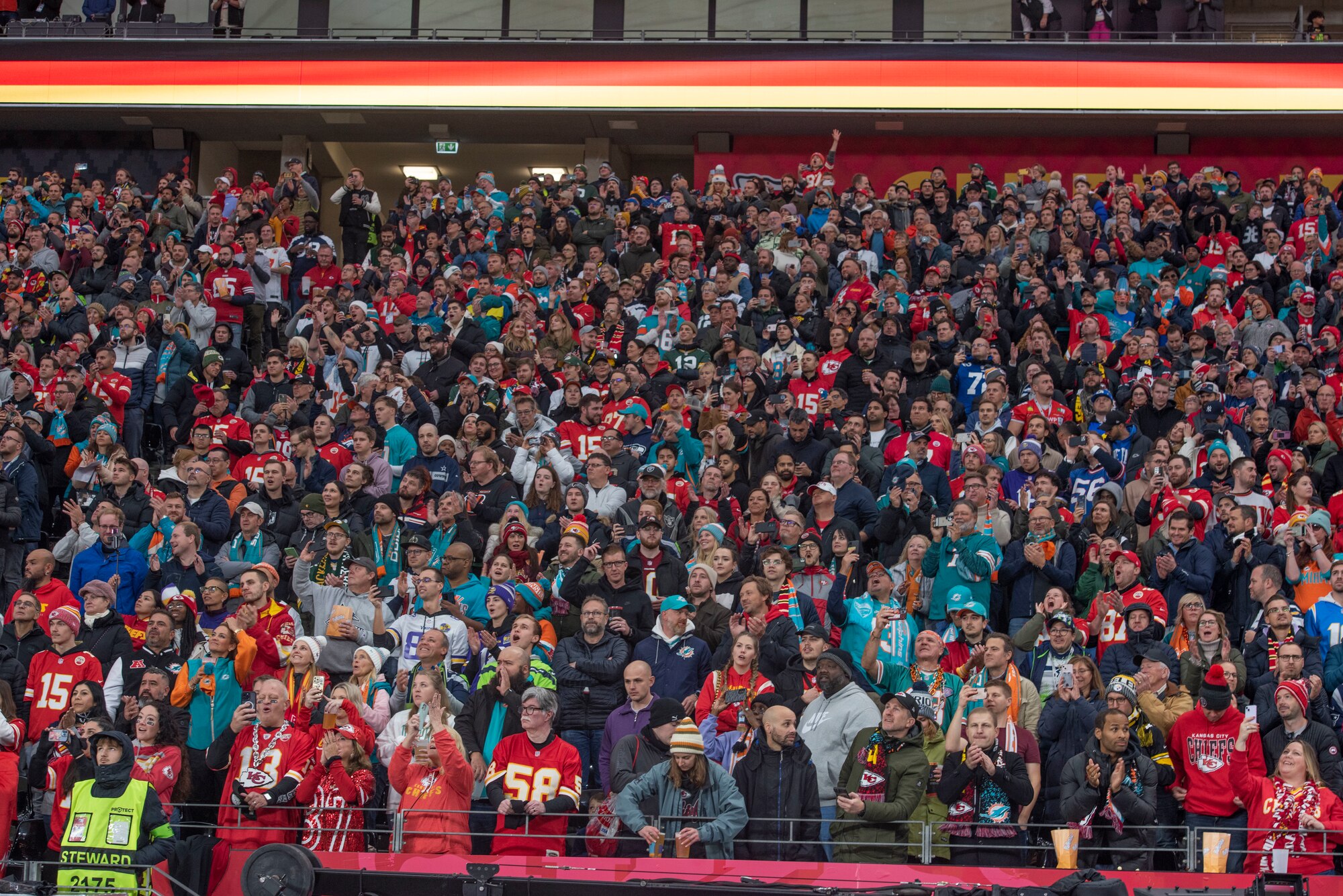 Many people cheer for a football game in the stands