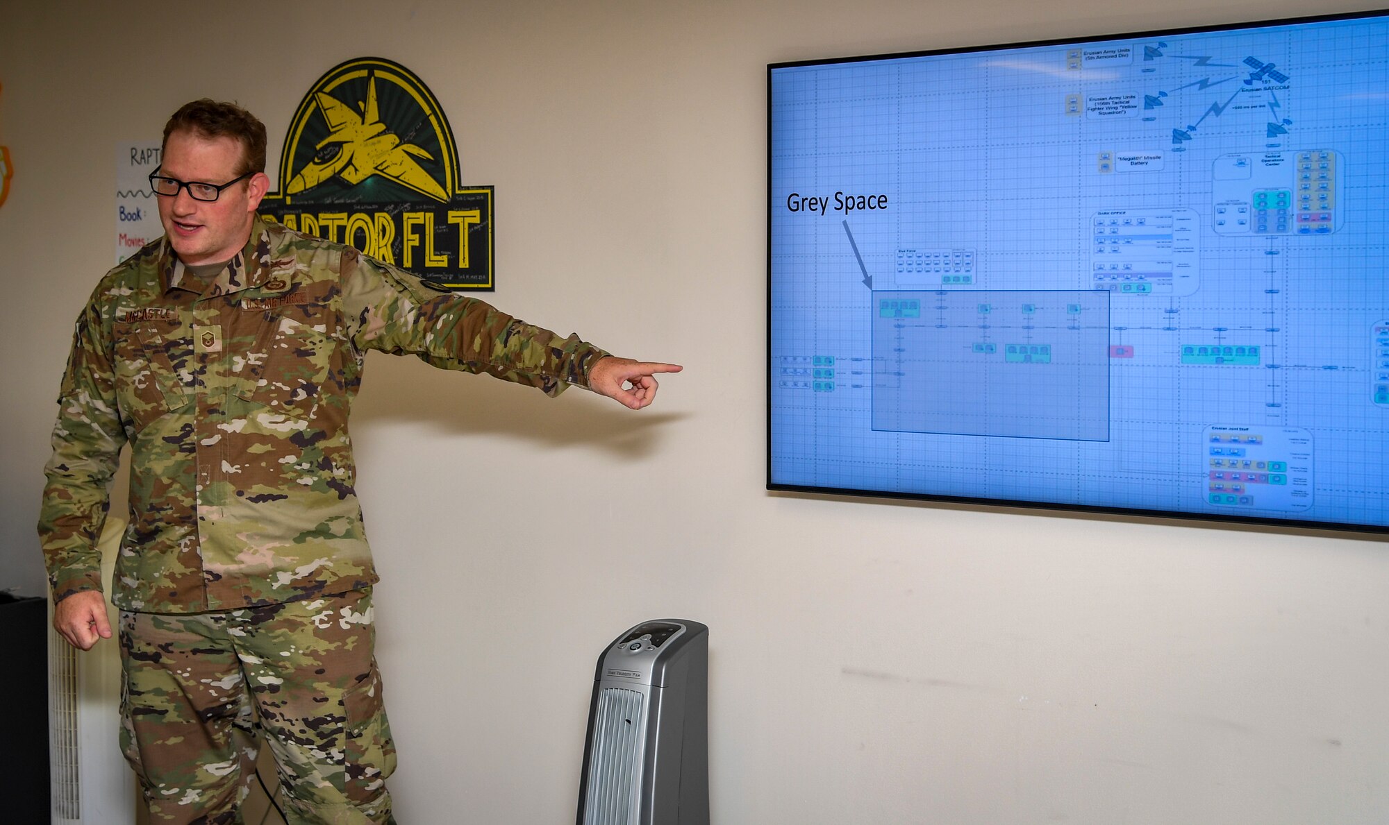 A guy points to a projector screen.