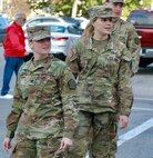 Illinois Army National Guard Cpl. Miah Sally, Private 1st Class Breanne Kidd and Private Drew Tipton-Hicks look back at the parade after finishing it.