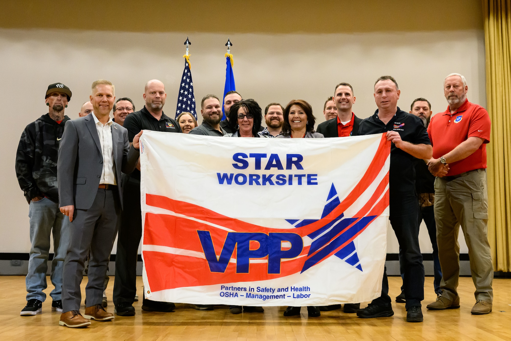 Members of the 309th Electronics Maintenance Group and Ogden Air Logistics Complex hold a VPP Star flag