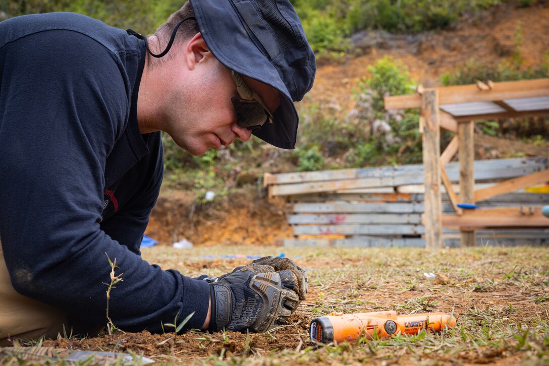 U.S. Marine Corps Staff Sgt. Robert Wendt, Defense POW/MIA Accounting Agency (DPAA) Short Term Individual Augmentee (STIA), conducts an Explosive Ordnance Disposal (EOD) survey during a DPAA recovery mission in the Lao People’s Democratic Republic (Lao PDR), Nov. 1, 2023. Before excavation begins, EOD technicians sweep for any unexploded ordnance or munitions that could be harmful to fellow team members. There are currently 1,578 missing personnel from the Vietnam War. (U.S. Air Force photo by Staff Sgt. Blake Gonzales)