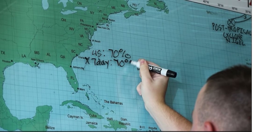 A Marine writes on a map.