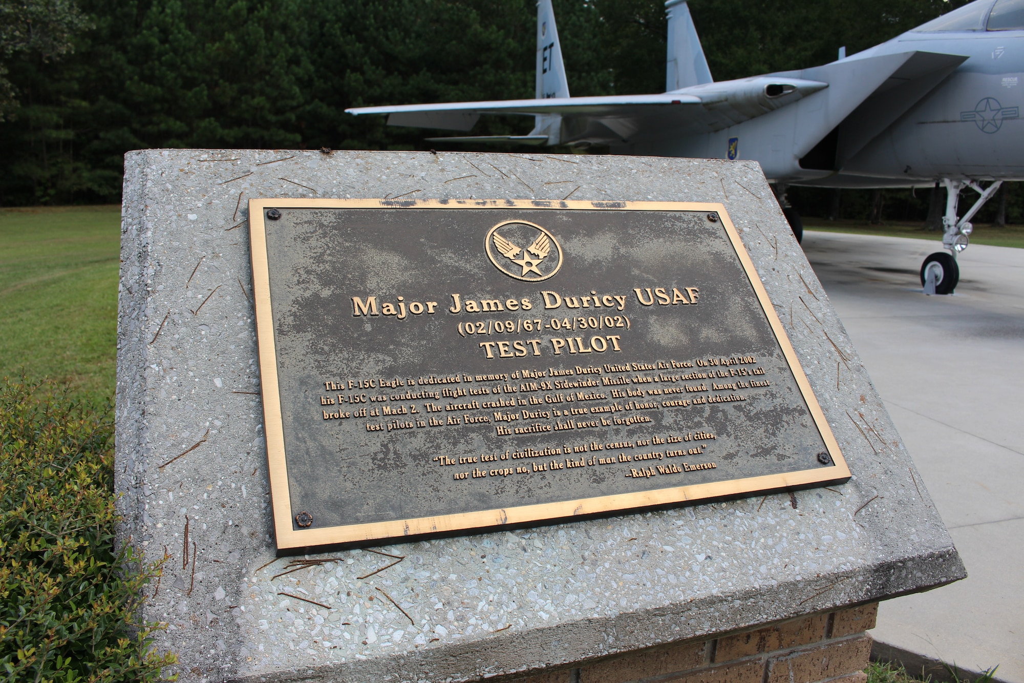 This plaque is located next to the static F-15 Eagle on display outside the Main Gate at Arnold Air Force Base, Tenn. The display is dedicated to Maj. Jim Duricy. He died April 30, 2002, when he was forced to eject at a high speed as the F-15C he piloted crashed into the Gulf of Mexico. His body was never found. A 12-year test pilot, Duricy was assigned to the 40th Flight Test Squadron based at Eglin Air Force Base, Fla., at the time of his death. He was on a captive flight development test of a new missile when the aircraft crashed. (U.S. Air Force photo by Kali Bradford)