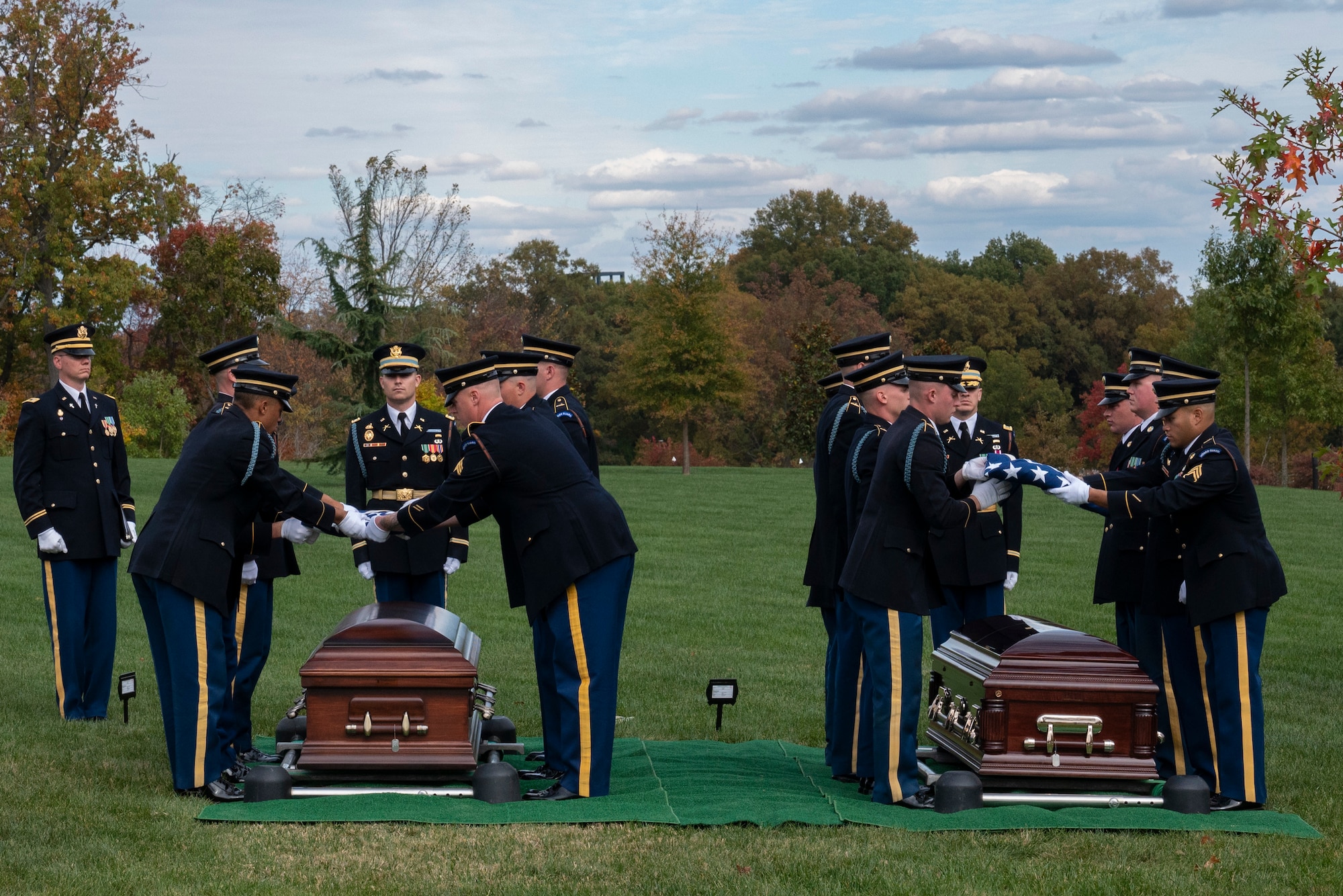 Flags are folded over caskets.
