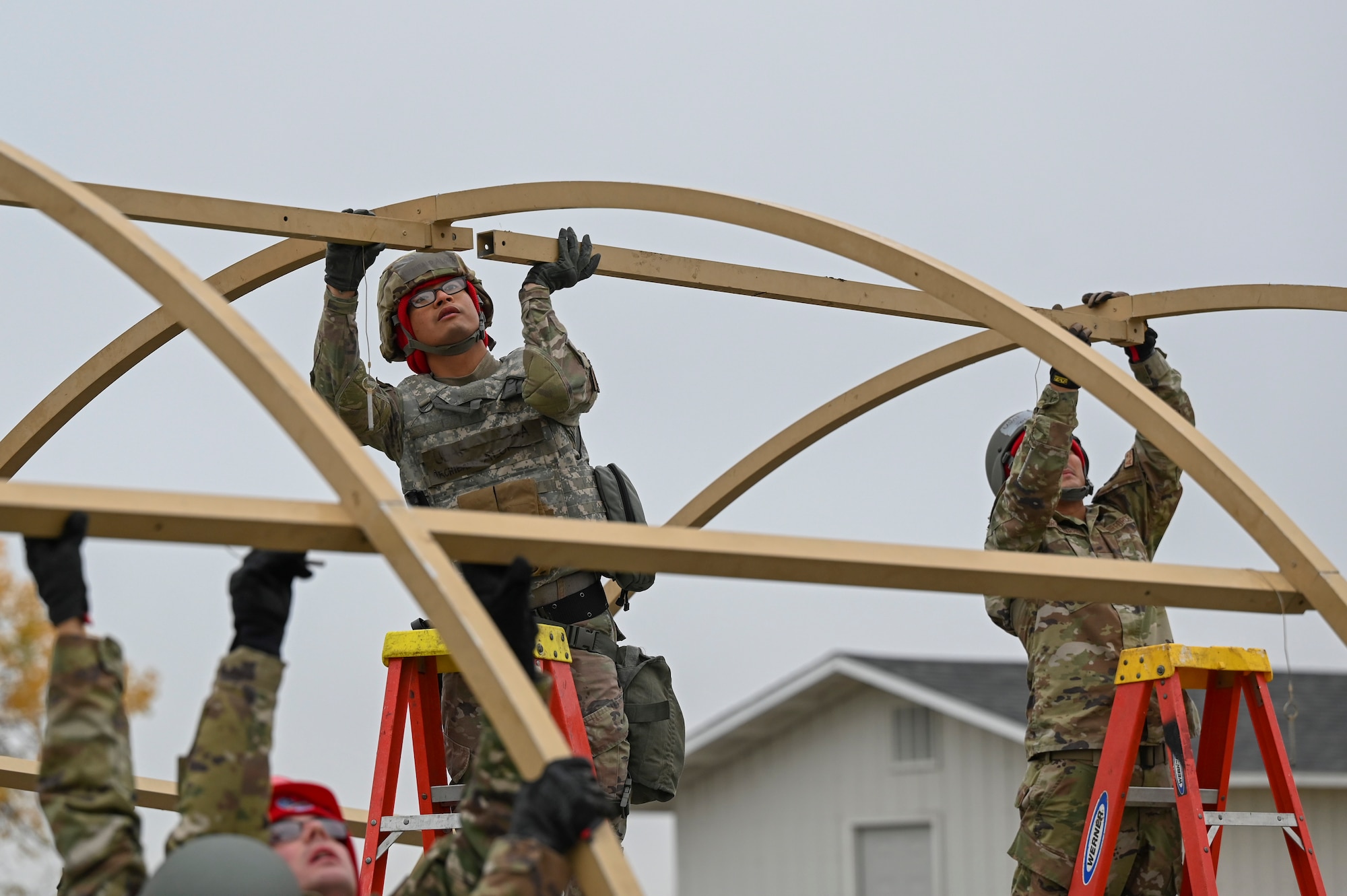 Multiple Airmen build a tent.