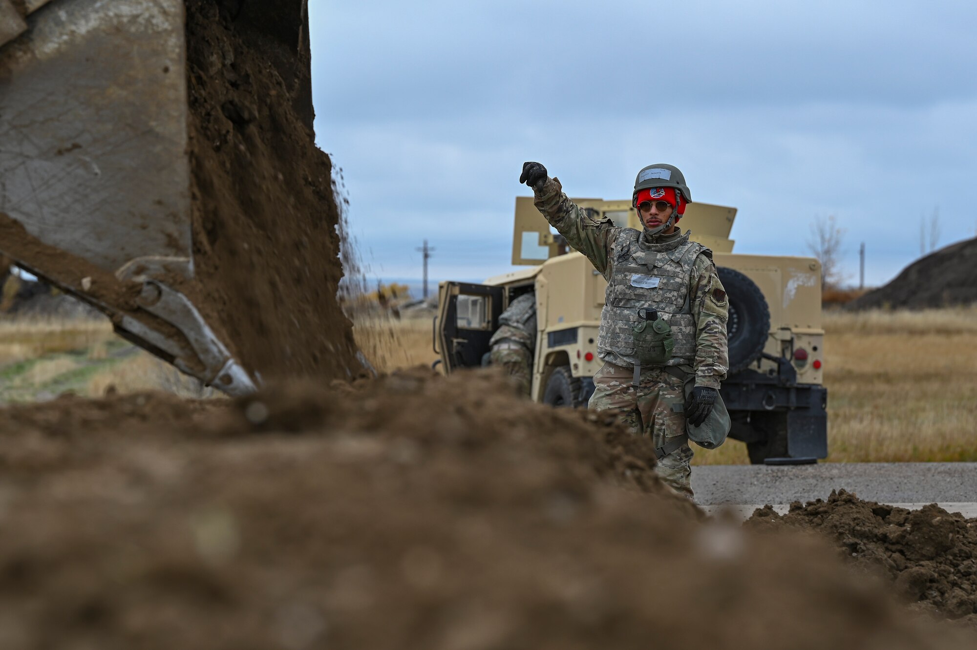 A person directs the dumping of dirt.