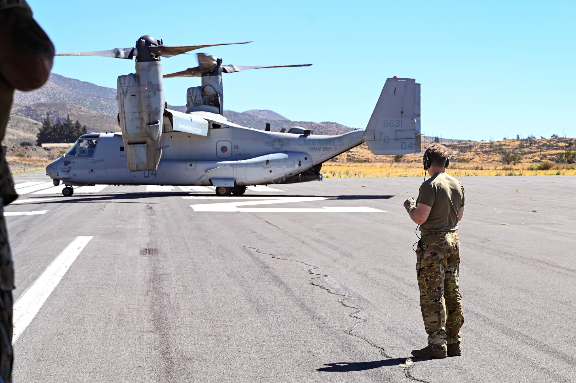 A U.S. Airman looks at a MV-22B Osprey while conducting Forward Area Refueling Point operations.