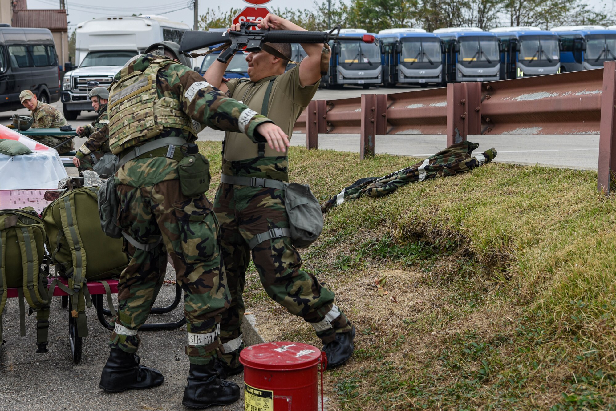 U.S. Air Force Airman 1st Class Tobin Miller, and Senior Airman David Vargas Figueroa, 51st Logistics Readiness Squadron vehicle operators, simulate an altercation for wing inspection team members to evaluate detaining procedures during Vigilant Defense 24 at Osan Air Base, Republic of Korea, Nov 1, 2023. The Airmen of the 51st Fighter Wing demonstrate multi-capable warfighter skills including initiative, problem solving, and adaptability necessary in the event of a real world threat. VD24 is a routine training event that tests the military capabilities across the peninsula, allowing combined and joint training at both the operational and tactical levels.  (U.S. Air Force photo by Airman 1st Class Chase Verzaal)