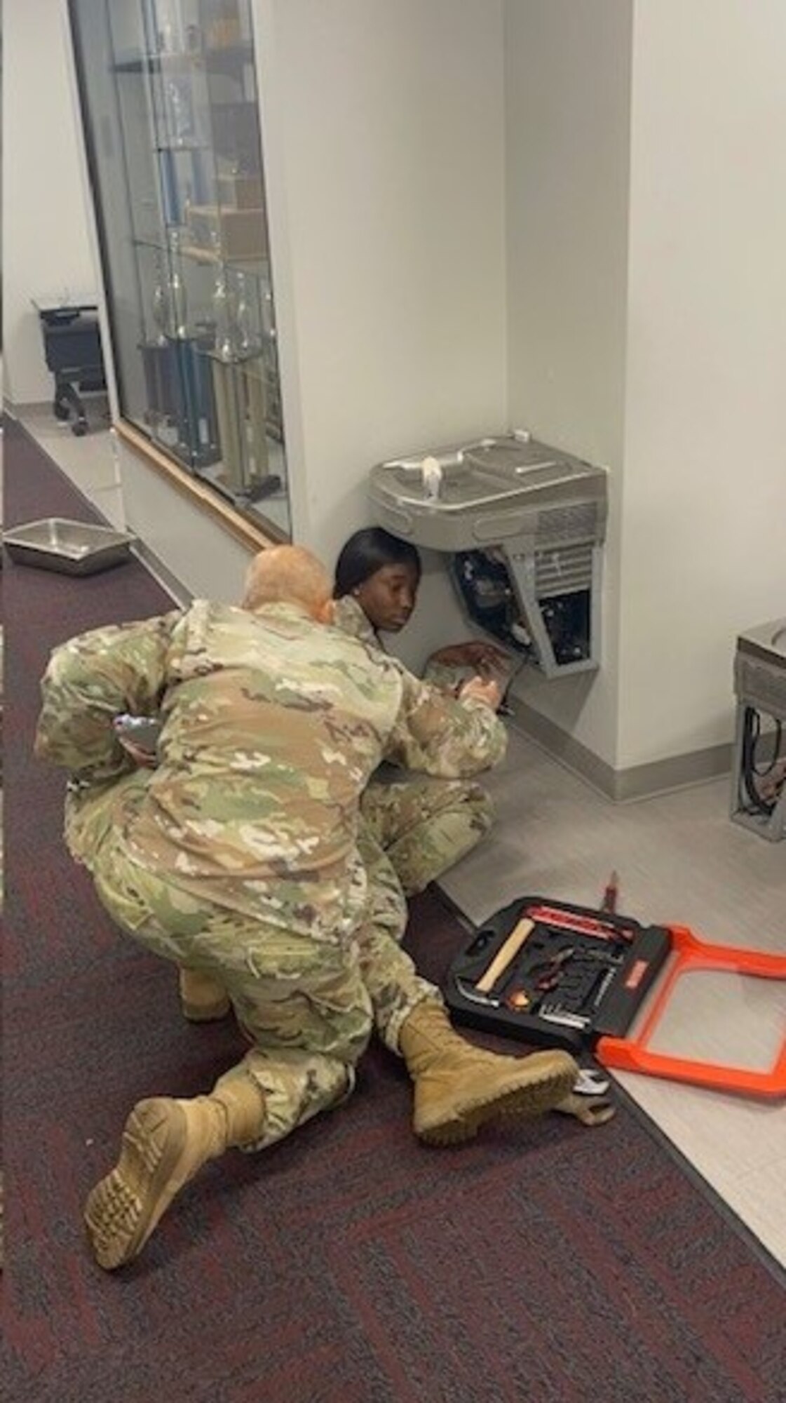 two people fix a water fountain