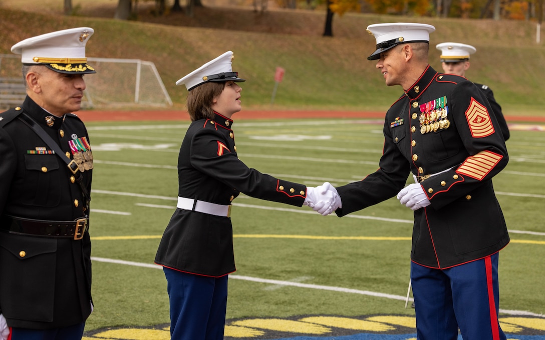 U.S. Marine Corps PFC. Faith Smith, administration specialist, left, shakes hands with Sgt. Maj. Carlos A. Ruiz, 20th Sergeant Major of the Marine Corps, a native of Sonora, Mexico, right, during the Marine Corps cake cutting ceremony in honor of the 248th Marine Corps Birthday at Butler Stadium on MCBQ, Virginia, Nov. 7, 2023. The annual cake cutting ceremony is a long-standing tradition that celebrates the establishment of the United States Marine Corps. The Marine Corps birthday is celebrated every year to commemorate the birth of the Corps and honor the service and sacrifices of all Marines, past and present. Smith is the youngest Marine on MCBQ. (U.S. Marine Corps photo by Cpl. Mitchell Johnson)