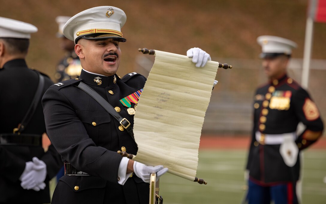 U.S. Marine Corps Capt. Moses Menchaca, battalion adjutant, security battalion, a native of Patterson, California, delivers the birthday message during the Marine Corps cake cutting ceremony in honor of the 248th Marine Corps Birthday at Butler Stadium on MCBQ, Virginia, Nov. 7, 2023. The annual cake cutting ceremony is a long-standing tradition that celebrates the establishment of the United States Marine Corps. The Marine Corps birthday is celebrated every year to commemorate the birth of the Corps and honor the service and sacrifices of all Marines, past and present. (U.S. Marine Corps photo by Cpl. Mitchell Johnson)