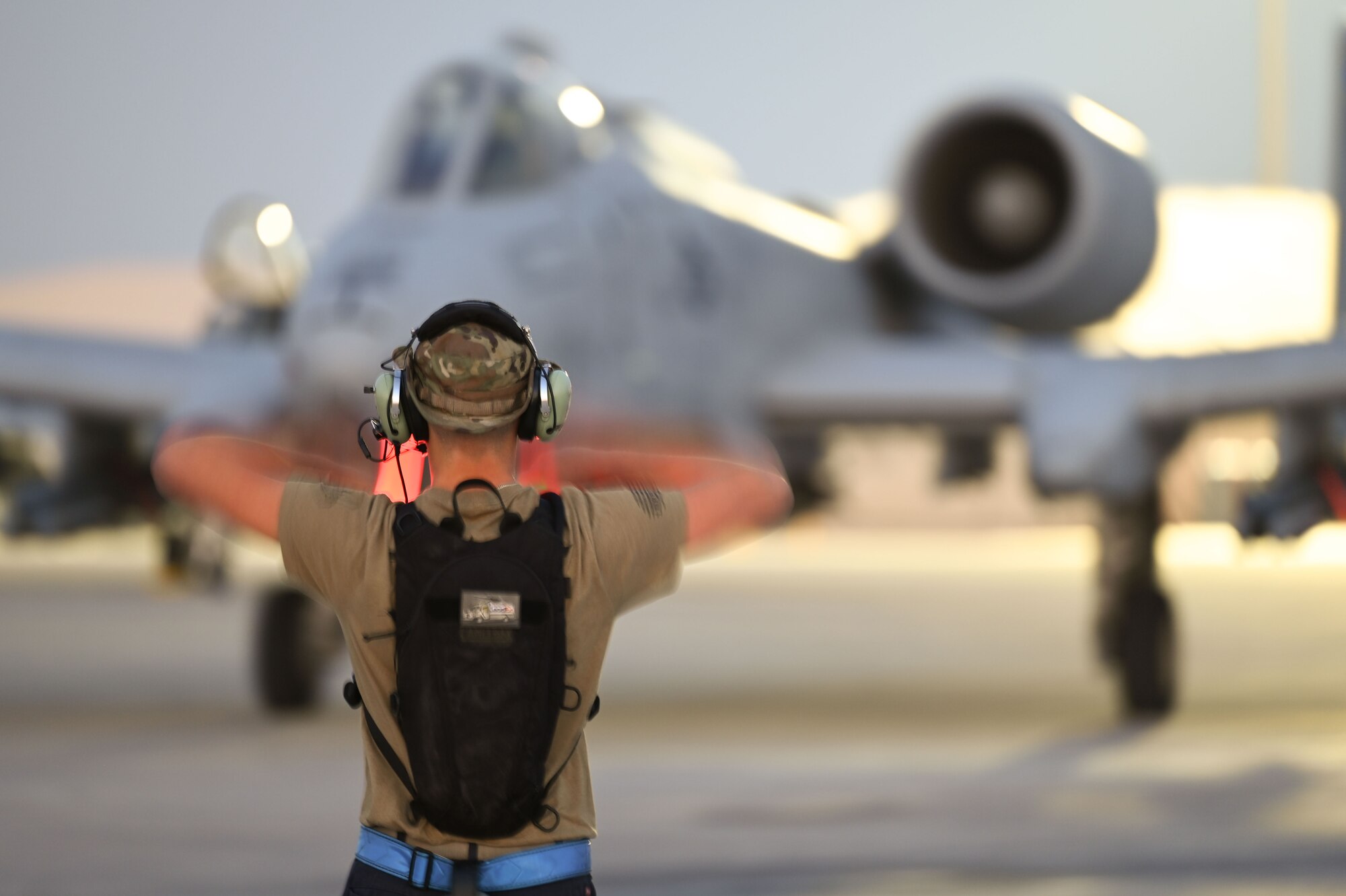 An Airman directs an A-10 Thunderbolt II pilot to their parking location.