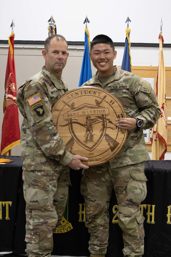 Spc. Jackie Zheng receives Soldier of the Year plaque from Kentucky National Guard State Command Sgt. Maj. Jesse Withers at the conclusion of the 2023 Kentucky Best Warrior Competition at Wendell H. Ford Regional Training Center, Greenville, Kentucky, November 5, 2023. The four-day competition tested Soldiers on strength, stamina, and common soldiering skills. (U.S. Army National Guard photo by Capt. Cody Stagner)