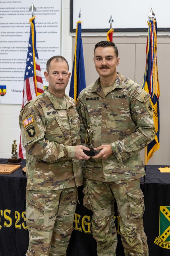 Sgt. Jerry Marksbury III, receives the Runner Up trophy from Kentucky National Guard State Command Sgt. Maj. Jesse Withers during a ceremony at the conclusion of the 2023 Kentucky Best Warrior Competition at Wendell H. Ford Regional Training Center, Greenville, Kentucky, November 5, 2023. Sgt. Robert Buck and Spc. Jackie Zheng receive NCO of the Year and Soldier of the Year. (U.S. Army National Guard photo by Capt. Cody Stagner)