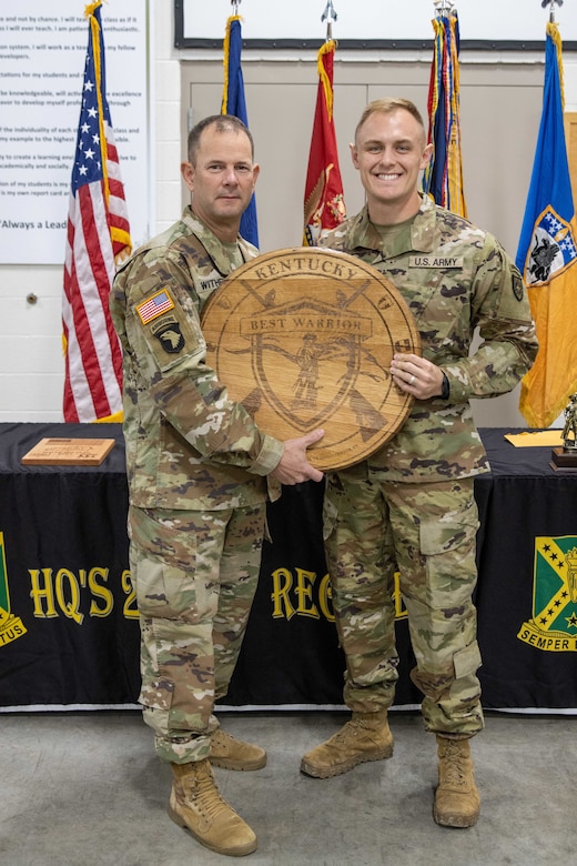 Sgt. Robert Buck receives the NCO of the Year plaque from Kentucky National Guard State Command Sgt. Maj. Jesse Withers at the conclusion of the 2023 Kentucky Best Warrior Competition at Wendell H. Ford Regional Training Center, Greenville, Kentucky, November 5, 2023. The four-day competition tested Soldiers on strength, stamina, and common soldiering skills. (U.S. Army National Guard photo by Capt. Cody Stagner)