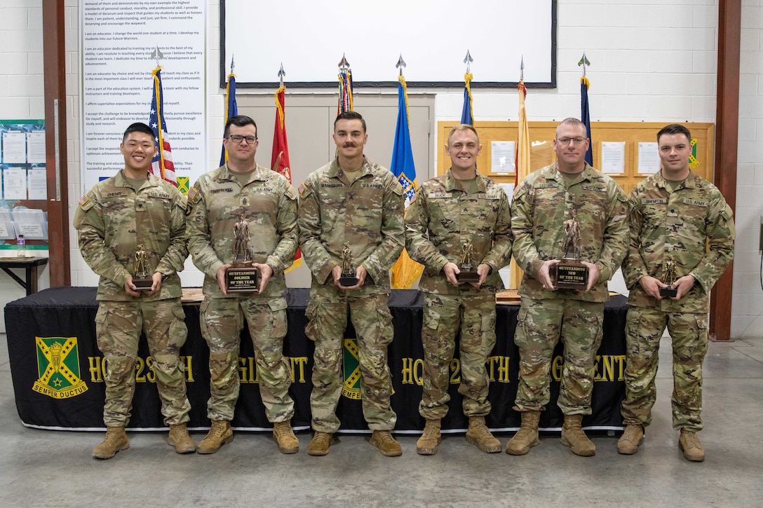 Soldiers who competed in Kentucky's Best Warrior Competition received trophies during a ceremony held in Wendell H. Ford Regional Training Center in Greenville, Kentucky, November 5, 2023. From left: Spc. Jackie Zheng, Soldier of the Year; Command Sgt. Maj. Benzie Timberlake, 75th Troop Command; Sgt. Jerry Marksbury III, NCO of the Year Runner-Up; Sgt. Robert Buck, NCO of the Year; Command Sgt. Maj. Aaron Lester, 149th Maneuver Enhancement Brigade; and Spc. Stephen Shelton, Soldier of the Year Runner-Up.  (U.S. Army National Guard photo by Capt. Cody Stagner)