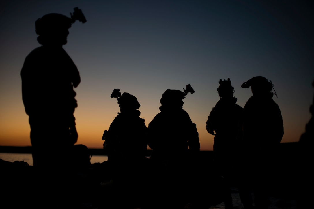 British Royal Marines Commandos assigned to 40 Commando, currently attached to the 15th Marine Expeditionary Unit, sit on a combat rubber raiding craft prior to conducting night small boat training with Reconnaissance Company, 15th MEU, California, Oct. 4, 2023. Utilizing small boats to conduct a low-light amphibious landing permits Reconnaissance Company Marines to locate, approach, seize and hold key maritime terrain, and conduct reconnaissance and counter-reconnaissance under the cover of darkness. (U.S. Marine Corps photo by Sgt. Patrick Katz)