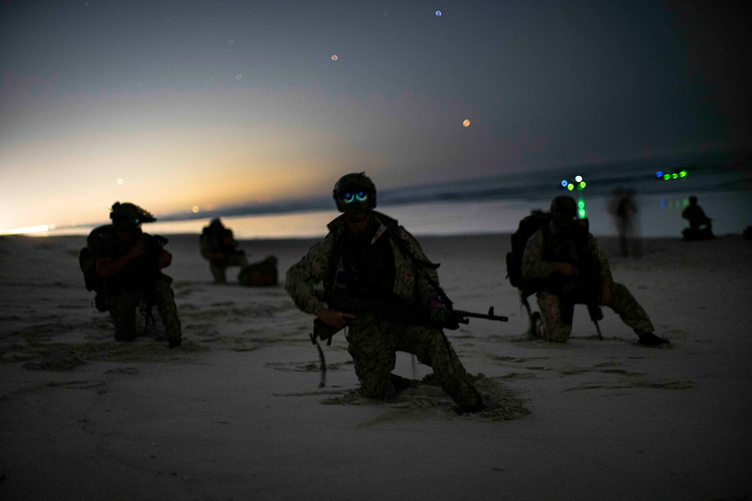 U.S. Marines assigned to Reconnaissance Company, 15th Marine Expeditionary Unit, hold security after landing ashore during night small boat training at Marine Corps Base Camp Pendleton, California, Oct. 4, 2023. Utilizing small boats to conduct a low-light amphibious landing permits Reconnaissance Company Marines to locate, approach, seize and hold key maritime terrain, and conduct reconnaissance and counter-reconnaissance under the cover of darkness. (U.S. Marine Corps photo by Sgt. Patrick Katz)
