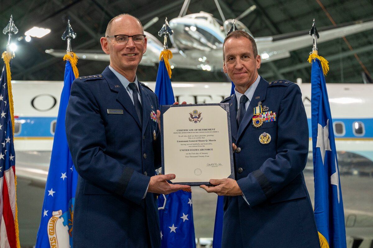 Two men on stage wearing dress Air Force uniforms.