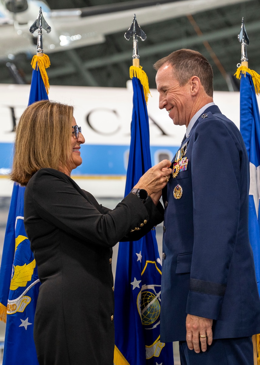 Jean Morris, spouse of Lt. Gen. Shaun Q. Morris, Air Force Life Cycle Management Center commander, places the retirement pin on her husband’s uniform during his retirement ceremony.