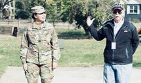 Illinois State Military Museum volunteer Richard Schachtsiek of Springfield explains the advancements in the modern Army uniform from World War I with Illinois Army National Guard Cpl. Marina Lopez-Melgoza serving as a model.