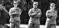 Illinois Army National Guard Soldiers (from left) Chief Warrant Officer Kelly Malcom, Cpl. Marina Lopez-Melgoza, and Sgt. 1st Class Savannah Bates listen as Illinois State Military Museum volunteer and German Infantry Soldier re-enact Bjorn Ganger of Tonica, Illinois, explains how the German forces were more advanced in chemical warfare with gas masks with charcoal filters.