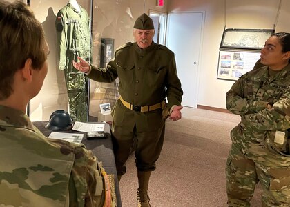 J. Perkins, a volunteer with the First Infantry Division Museum at Cantigny Park in Wheaton, Illinois, explains to Illinois Army National Guard Chief Warrant Officer 3 Kelly Malcom how U.S. Soldiers also served in places such as Siberia and Italy during World War I in addition to France.