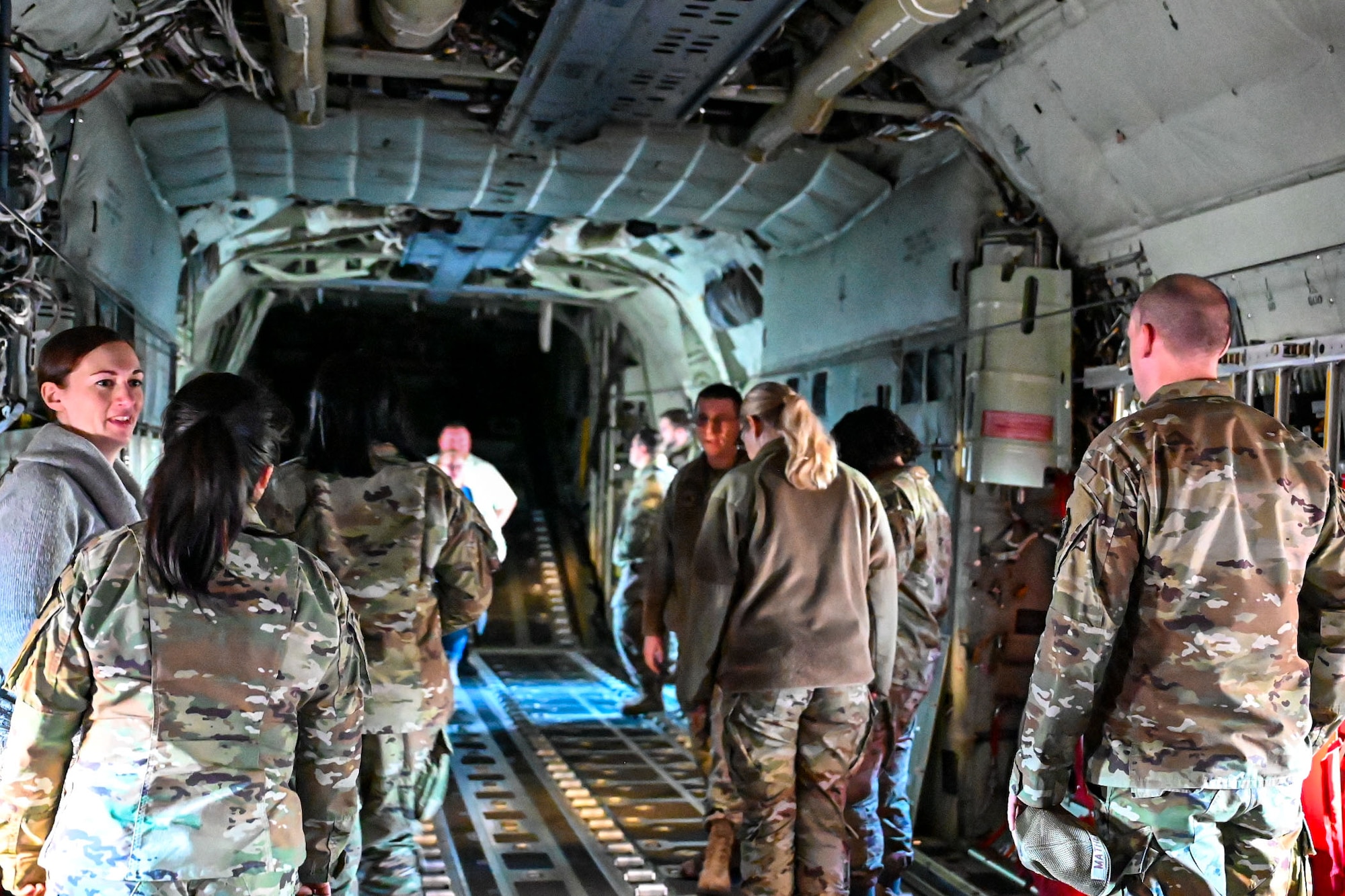 U.S. Airmen and providers stand in a C-130J aircraft.