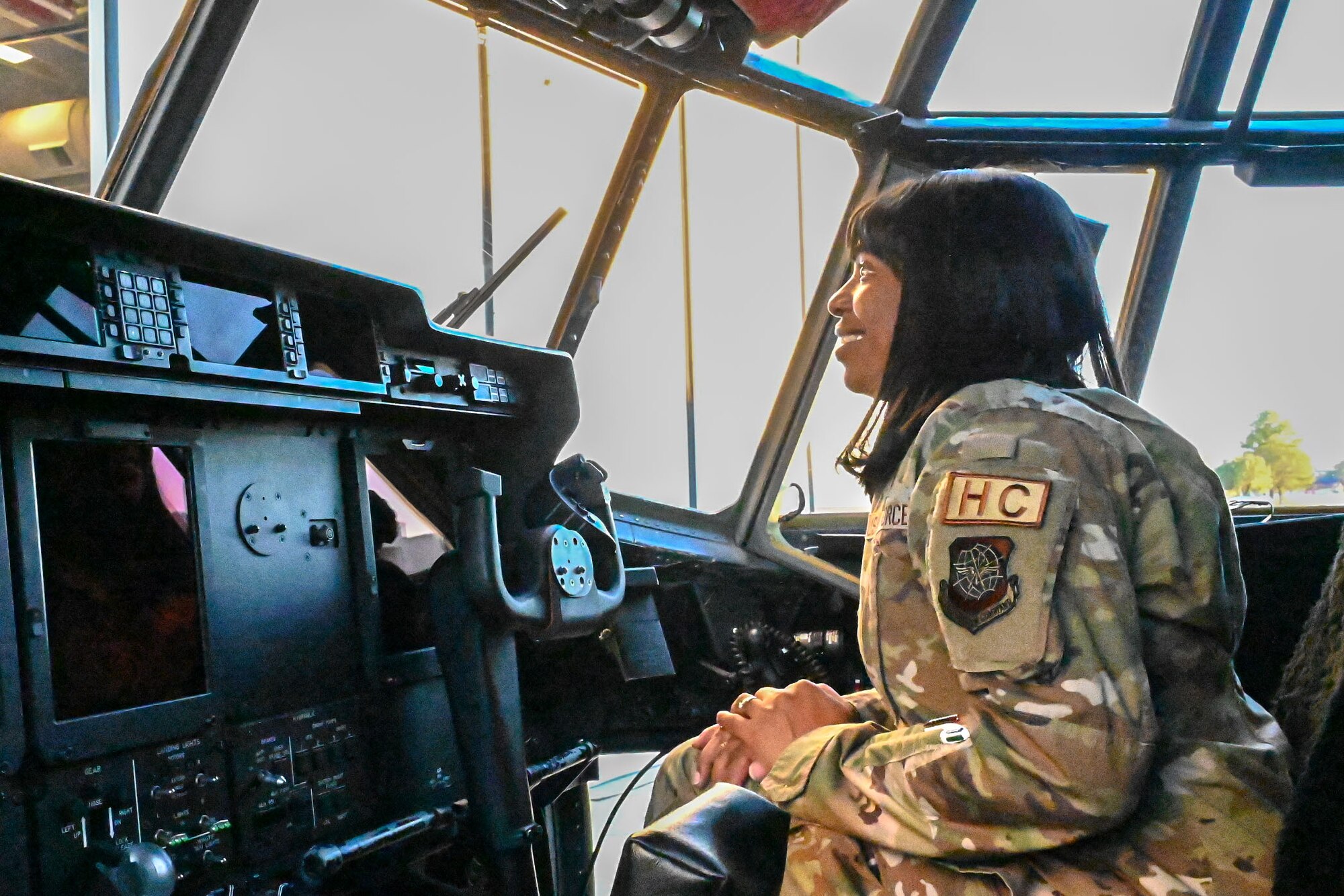 A U.S. Airman sits in the cockpit of a C-130J aircraft.