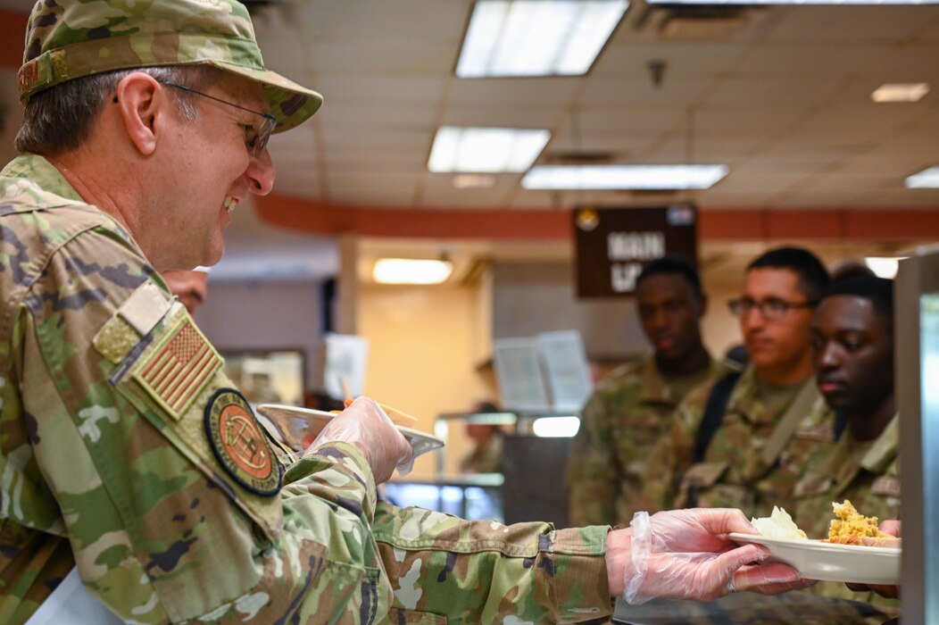 Maj. Gen. John Bartrum, Mobilization Assistant to the Surgeon General of the Air Force and Space Force, hands a plate to 433rd Airlift Wing Airmen during the “Feed the Airmen” Luncheon event at Joint Base San Antonio-Lackland, Texas, Nov. 4, 2023.