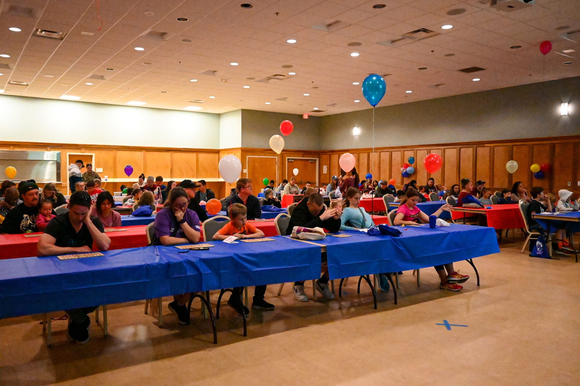 People sit at tables in a large room.