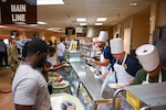 Maj. Gen. John Bartrum, Mobilization Assistant to the Surgeon General of the Air Force and Space Force, hands a plate to 433rd Airlift Wing Airmen during the “Feed the Airmen” Luncheon event at Joint Base San Antonio-Lackland, Texas, Nov. 4, 2023.