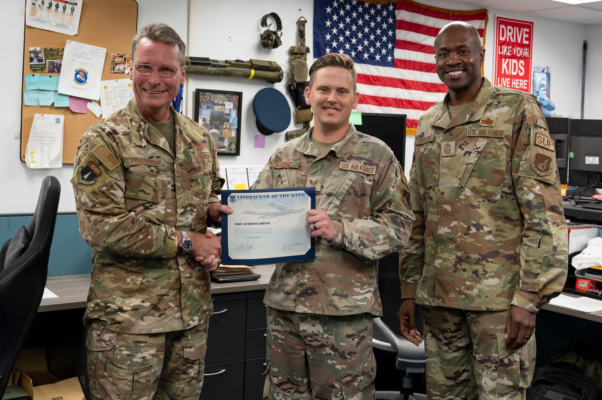 U.S. Air Force Staff Sgt. Anthony Lorenz, the unit deployment manager assigned to the 36th Force Support Squadron, receives the Linebacker of the Week Award from U.S. Air Force Brig. Gen. Thomas Palenske, commander of the 36th Wing, and U.S. Air Force Chief Master Sgt. Nicholas Taylor, command chief of the 36th Wing, at Andersen Air Force Base, Guam, Nov. 1, 2023. The Team Andersen Linebacker of the Week recognizes outstanding enlisted, officer, civilian and total force personnel who have had an impact on achieving Team Andersen’s mission, vision and priorities. (U.S. Air Force photo by Senior Airman Emily Saxton)