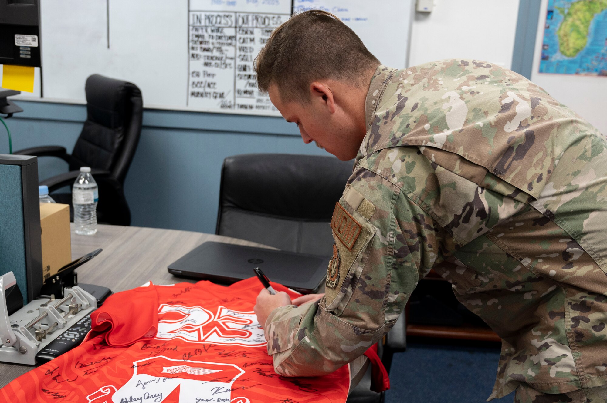 U.S. Air Force Staff Sgt. Anthony Lorenz, the unit deployment manager assigned to the 36th Force Support Squadron, signs the Linebacker of the Week jersey at Andersen Air Force Base, Guam, Nov. 1, 2023. The Team Andersen Linebacker of the Week recognizes outstanding enlisted, officer, civilian and total force personnel who have had an impact on achieving Team Andersen’s mission, vision and priorities. (U.S. Air Force photo by Senior Airman Emily Saxton)