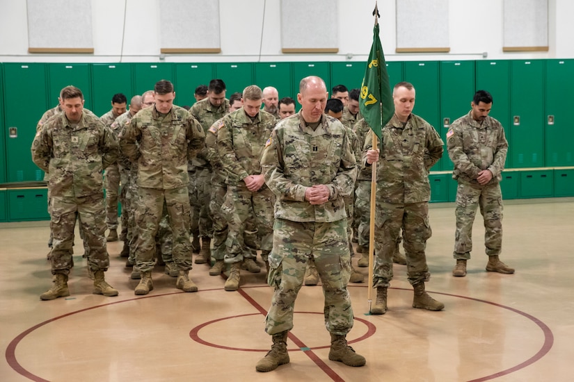 Alaska Army National Guard Capt. Michael Thrall, outgoing commander of the 297th Military Police Company, bows his head at the front of his formation during the benediction as part of a deactivation ceremony for the company at the Alcantra Armory in Wasilla, Alaska, Nov. 2, 2023.