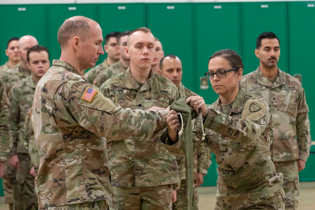 Alaska Army National Guard Capt. Michael Thrall, left, outgoing commander, and 1st Sgt. Bethany Amarone, outgoing noncommissioned officer in charge, both assigned to the 297th Military Police Company, retire the colors of the unit’s flag as part of a deactivation ceremony for the company at the Alcantra Armory in Wasilla, Alaska, Nov. 2, 2023.