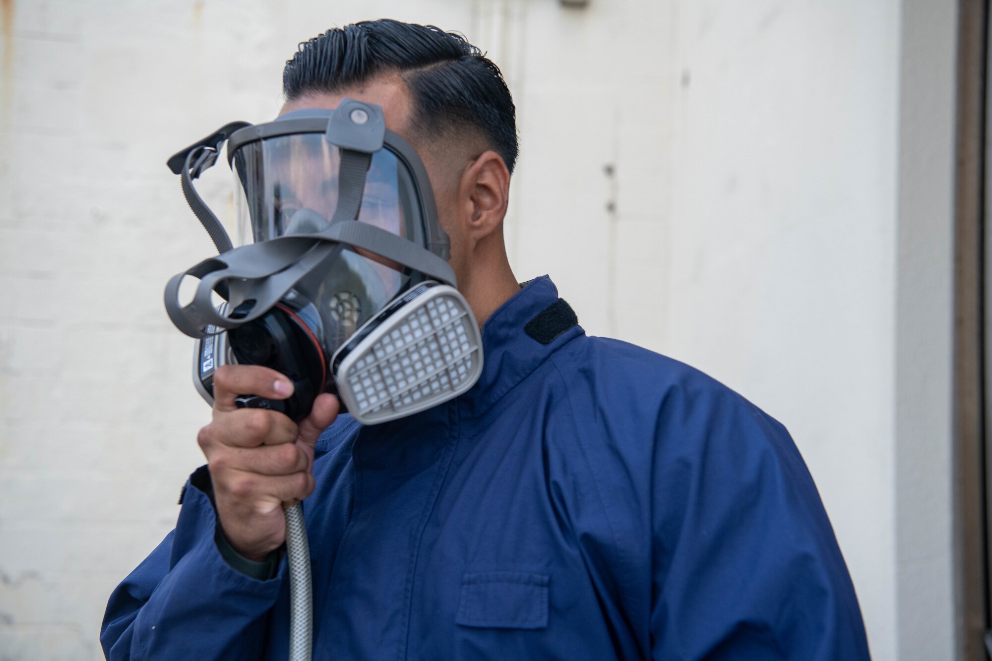 Staff Sgt. Allen Gonzales puts on breathing mask equipment for demonstration