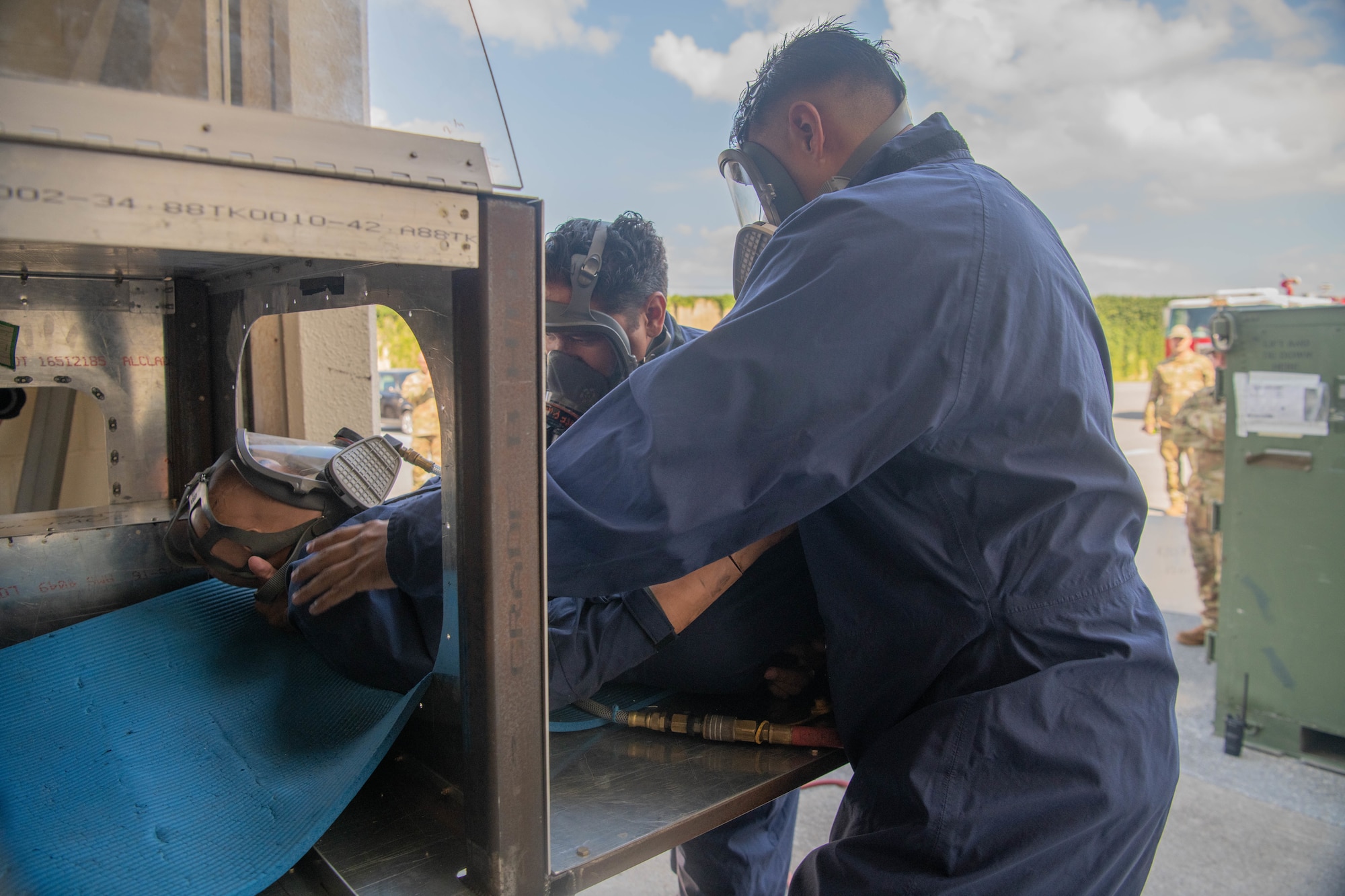 two craftsmen pull a mannequin out from a confined space