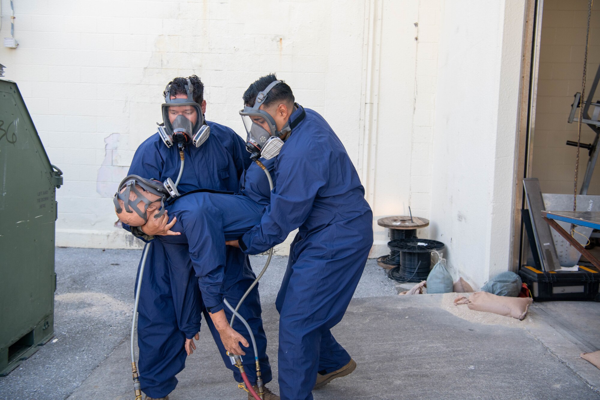 two craftsmen carry a mannequin out from extraction demonstration